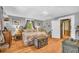Cozy bedroom features hardwood floors and vintage furnishings, with a wooden trunk at the foot of the floral bed at 215 Fair St, Loganville, GA 30052