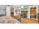Bedroom featuring hardwood floors, a decorative fireplace, TV, and a view into an organized walk-in closet at 215 Fair St, Loganville, GA 30052