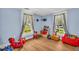 Bright bedroom featuring hardwood floors, light blue walls, and lots of toys at 215 Fair St, Loganville, GA 30052