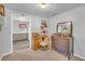 A room with carpet, neutral paint, a dresser and desk, and access to other spaces at 215 Fair St, Loganville, GA 30052