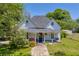 Charming two-story home featuring a welcoming front porch with swing, stone pathway, and well-maintained lawn at 215 Fair St, Loganville, GA 30052