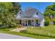 Charming two-story home featuring a welcoming front porch with swing, stone pathway, and well-maintained lawn at 215 Fair St, Loganville, GA 30052