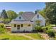 Two-story home showcasing an upper balcony, brick pathway, lush greenery, and charming architectural details at 215 Fair St, Loganville, GA 30052