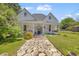 Classic white farmhouse with a welcoming front porch, stone pathway, and mature landscaping at 215 Fair St, Loganville, GA 30052
