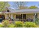 Charming front porch with a cozy seating area, decorative plants, and a welcoming ambiance at 215 Fair St, Loganville, GA 30052