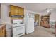 A kitchen and eat-in dining space includes classic cabinets, standard appliances, and neutral flooring at 215 Fair St, Loganville, GA 30052
