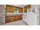 Traditional kitchen featuring wood cabinets, white appliances, and a window over the sink at 215 Fair St, Loganville, GA 30052