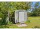 Small, functional metal shed surrounded by trees, providing extra storage space in backyard at 215 Fair St, Loganville, GA 30052