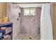Tiled walk-in shower with a built-in niche, window, and safety bar with a shower curtain at 215 Fair St, Loganville, GA 30052