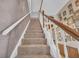 Carpeted staircase with wood and white railing, accented by photo gallery wall at 215 Fair St, Loganville, GA 30052