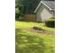 Well-maintained backyard with a large tree stump, lush green grass, and a privacy fence at 4184 Red Laurel Way, Snellville, GA 30039