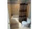Bathroom with tiled shower and tub featuring patterned shower curtain and tile flooring at 4184 Red Laurel Way, Snellville, GA 30039