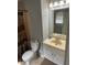 Bathroom featuring a marble counter top vanity, mirror, light bar and standard toilet at 4184 Red Laurel Way, Snellville, GA 30039