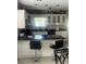 Cozy kitchen featuring white cabinets, a black countertop, and an island with barstool seating perfect for entertaining at 4184 Red Laurel Way, Snellville, GA 30039