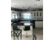 The well-lit kitchen features white cabinets, dark countertops, an island with bar seating, and stainless steel appliances at 4184 Red Laurel Way, Snellville, GA 30039
