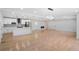 Bright living room with wood floors, recessed lighting, and a kitchen featuring modern appliances at 4307 Cedar Wood Sw Dr, Lilburn, GA 30047