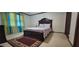 Bedroom featuring a luxurious dark wood bed, patterned rug, and large window with colorful curtains at 4662 Burns Rd, Lilburn, GA 30047