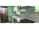Kitchen featuring green cabinets, stainless appliances, and a mosaic tile backsplash at 4662 Burns Rd, Lilburn, GA 30047