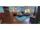 Cozy living room featuring a leather sectional, wood-paneled walls, and a bright blue area rug at 4662 Burns Rd, Lilburn, GA 30047