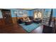 Cozy living room featuring a leather sectional, wood-paneled walls, and a bright blue area rug at 4662 Burns Rd, Lilburn, GA 30047