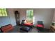 Bright sitting area with wicker furniture, including a table and chairs with red cushions at 4662 Burns Rd, Lilburn, GA 30047