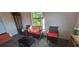 Cozy sitting area with wicker furniture, red cushions, and a bright window view at 4662 Burns Rd, Lilburn, GA 30047