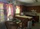 Compact kitchen with dark wood cabinets, simple countertops, and an adjacent dining area with wicker chairs at 5001 Panola Mill Dr, Lithonia, GA 30038