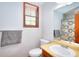 This well-lit bathroom features a white toilet, vanity and mirror, plus a shower with a patterned curtain at 2435 Farmer Road, Conyers, GA 30012