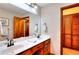 Bathroom features double sinks, wood cabinets, a large mirror, and a separate closet with louvered doors at 2435 Farmer Road, Conyers, GA 30012