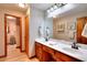 Well-lit bathroom featuring double sinks, wood cabinets, a large mirror, and a separate toilet area at 2435 Farmer Road, Conyers, GA 30012