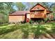 Rear exterior view of the home showcases the siding, brick foundation and manicured lawn at 2435 Farmer Road, Conyers, GA 30012