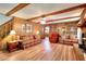 Cozy living room featuring wood paneling, wood beam ceiling, and a brick fireplace at 2435 Farmer Road, Conyers, GA 30012