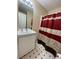 Modest bathroom features a single sink vanity, mirror, and patterned shower curtain at 1421 Isleworth Cir, College Park, GA 30349