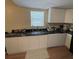 Modern kitchen showcasing sleek white cabinetry, black countertops, stainless steel sink, and contemporary fixtures at 1421 Isleworth Cir, College Park, GA 30349