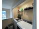 Bright laundry room featuring modern washer and dryer units with storage shelves and natural light from the window at 1421 Isleworth Cir, College Park, GA 30349