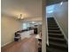 Open living space with hardwood floors leading to a kitchen and staircase under chandelier lighting at 1421 Isleworth Cir, College Park, GA 30349