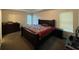 Comfortable main bedroom with tray ceiling, carpet flooring, and natural light from the windows at 1421 Isleworth Cir, College Park, GA 30349