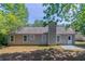 A view of the backyard featuring green trees, grass, neutral siding, windows and a concrete patio at 1363 To Lani Farm Rd, Stone Mountain, GA 30083