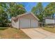 Attached two-car garage with driveway and well-maintained lawn and landscaping at 1363 To Lani Farm Rd, Stone Mountain, GA 30083
