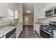 Modern kitchen with white cabinets, granite countertops, and stainless steel appliances and vinyl floors at 1363 To Lani Farm Rd, Stone Mountain, GA 30083