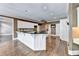 Open kitchen with hardwood floors, white cabinets, black countertops, and stainless steel appliances at 320 Chason Wood Way, Roswell, GA 30076