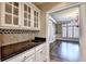 A kitchenette features light cabinets and a granite countertop bar area between rooms at 320 Chason Wood Way, Roswell, GA 30076