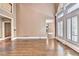Bright living room featuring hardwood floors, white trim, and tall windows with white shutters at 320 Chason Wood Way, Roswell, GA 30076