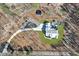 Aerial view of a home with a long driveway, patio, shed, and wooded surroundings at 1455 Rucker Cir, Woodstock, GA 30188