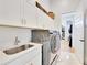 Functional laundry room with sink, modern washer and dryer, and ample storage space at 1455 Rucker Cir, Woodstock, GA 30188