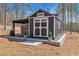 Charming shed with a covered wood storage area and classic black and white trim at 1455 Rucker Cir, Woodstock, GA 30188