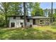 A white brick home with a spacious backyard surrounded by lush greenery and trees, offering a serene outdoor space at 3031 San Jose Dr, Decatur, GA 30032