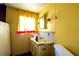 Bathroom featuring yellow walls, a sink with storage, a small mirror, and a single window at 1098 Cown Rd, Villa Rica, GA 30180