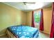Bedroom featuring neutral walls, a ceiling fan, and a window with red curtains overlooking the outdoors at 1098 Cown Rd, Villa Rica, GA 30180