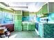 View of the kitchen featuring green cabinets, linoleum flooring, and multiple windows that bring in natural light at 1098 Cown Rd, Villa Rica, GA 30180